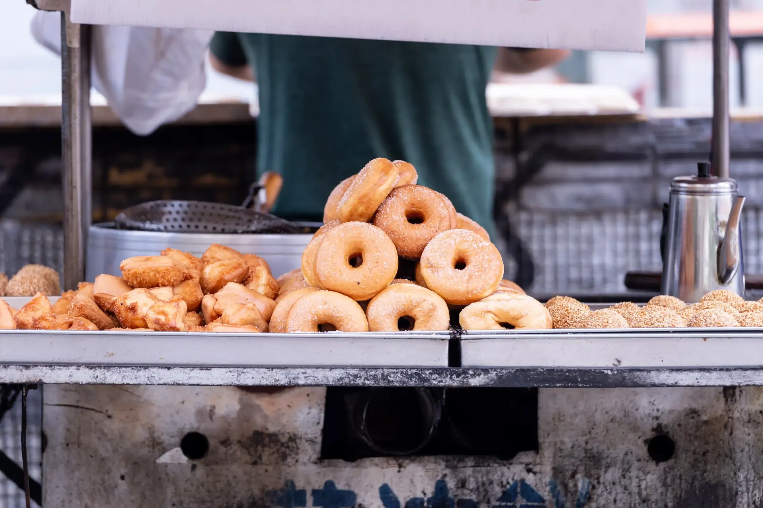 Two metal trays with different types of donuts